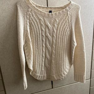 Selling a cream colored scoop neck sweater with round edges at the hips!